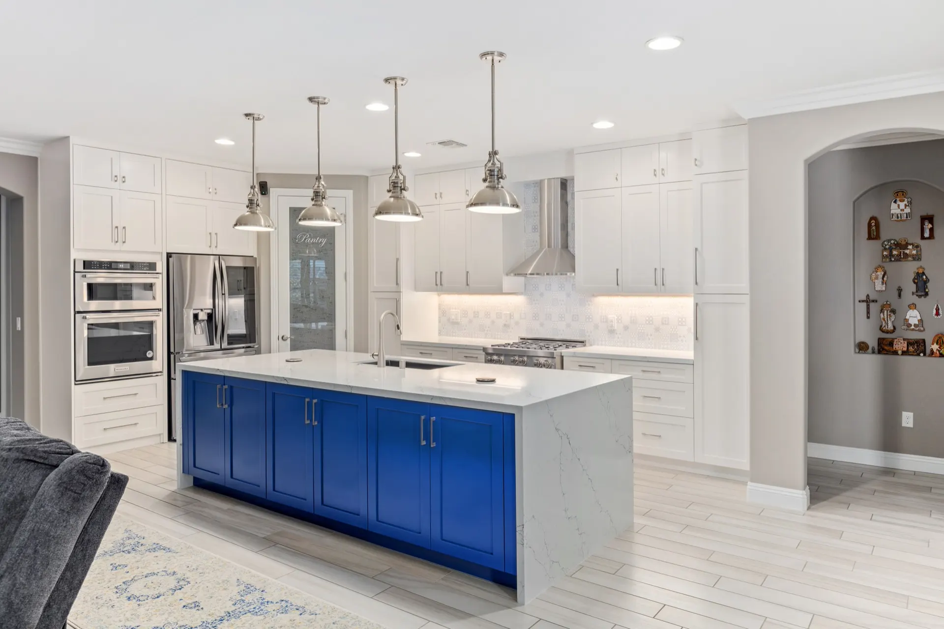 The same kitchen as built, with a navy island and white quartz