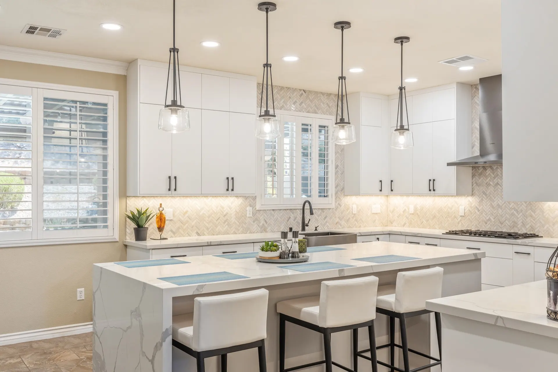 The same kitchen as built, in white with a marble-look island